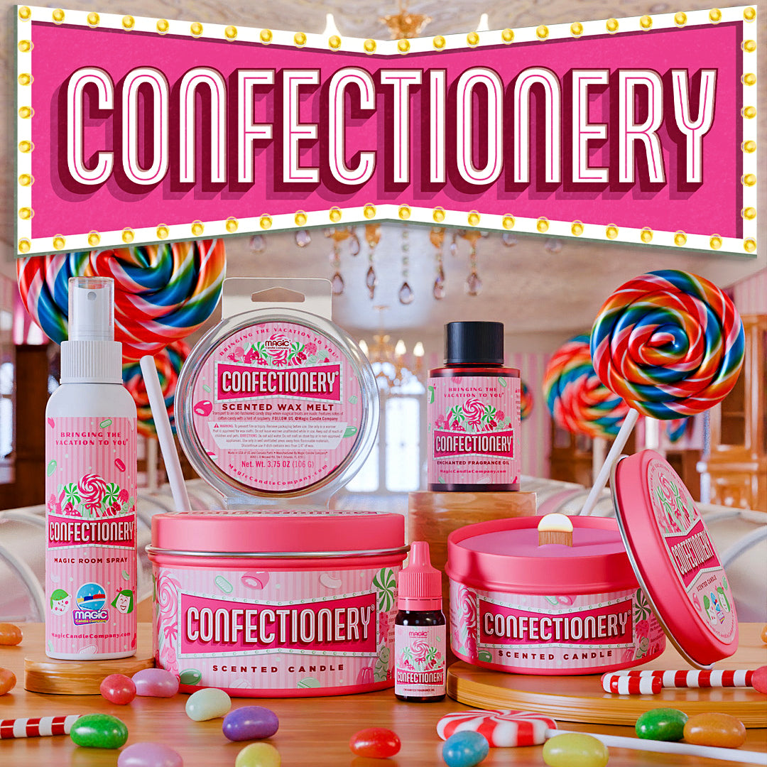 A styled product display for Confectionery scented candles and wax melts, featuring pink-labeled items including a candle tin, wax melt tin, spray bottle, and essential oil bottle, arranged with lollipops, candy, and a large pink sign reading CONFECTIONERY in a decorative indoor setting.